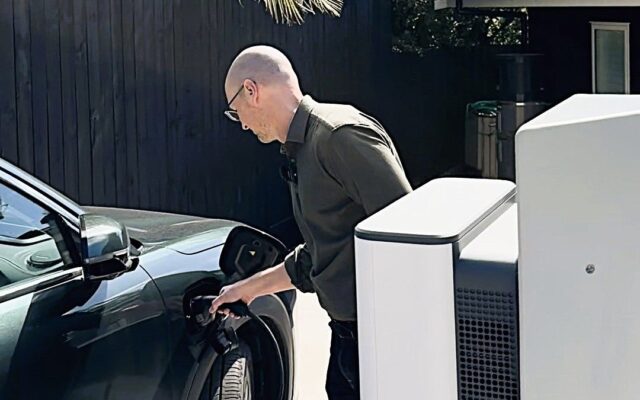 James Ryan plugs a Geely EV into a StarCharge Halo bidirectional charger at home in Auckland
