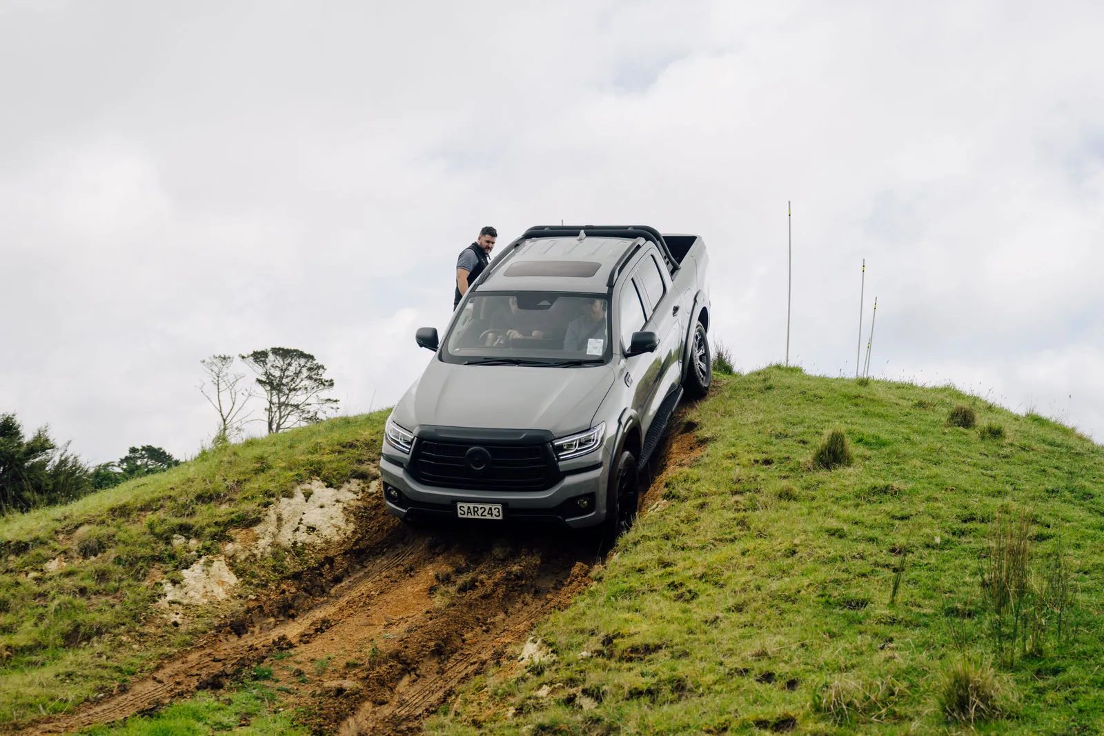 GWM Cannon Hi4-T PHEV climbing a muddy clay bank on a farm track