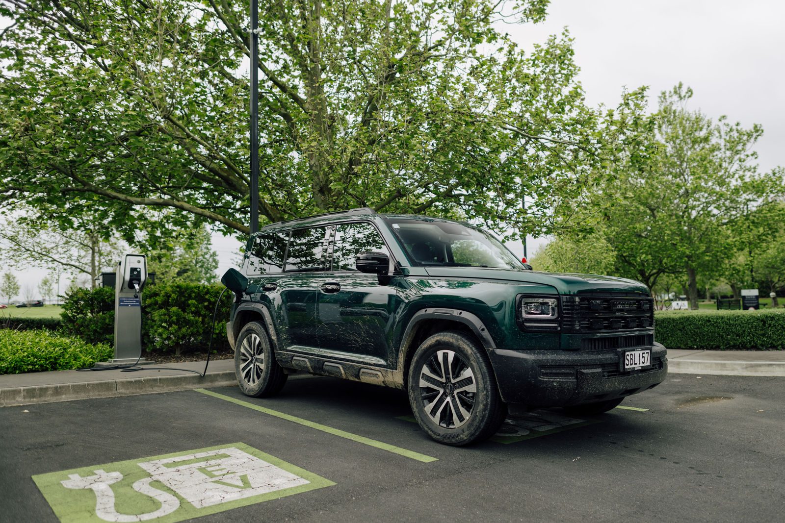 Green Haval H7 PHEV parked at an EV charging bay