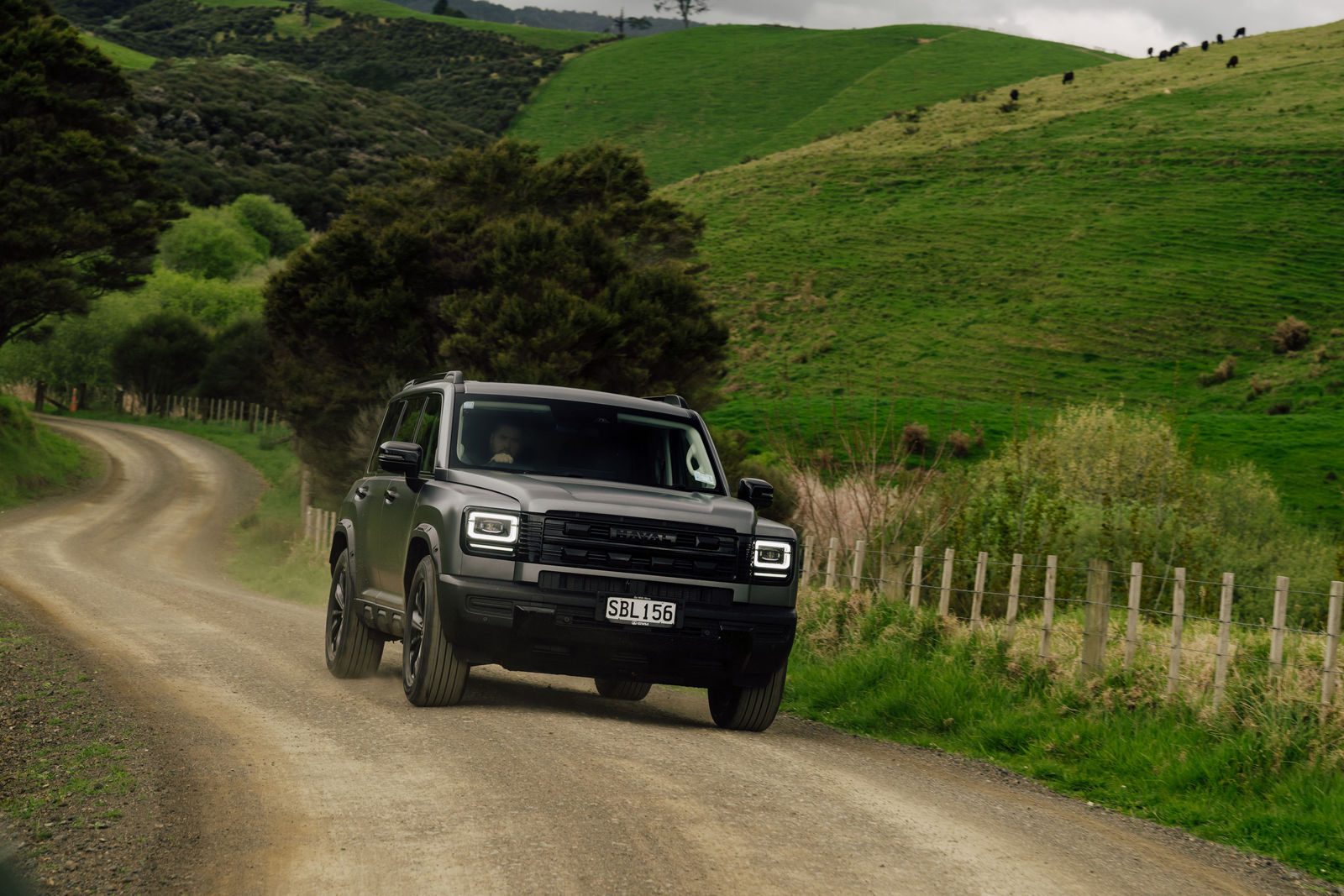 Matte grey Haval H7 on a gravel road through farmland