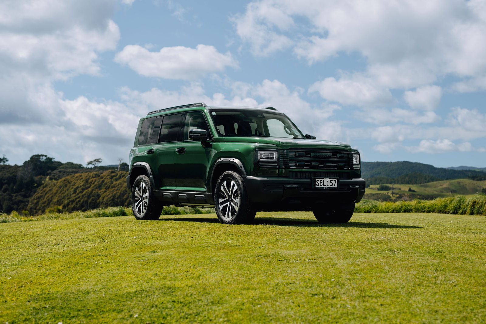 Green Haval H7 on a grassy hilltop