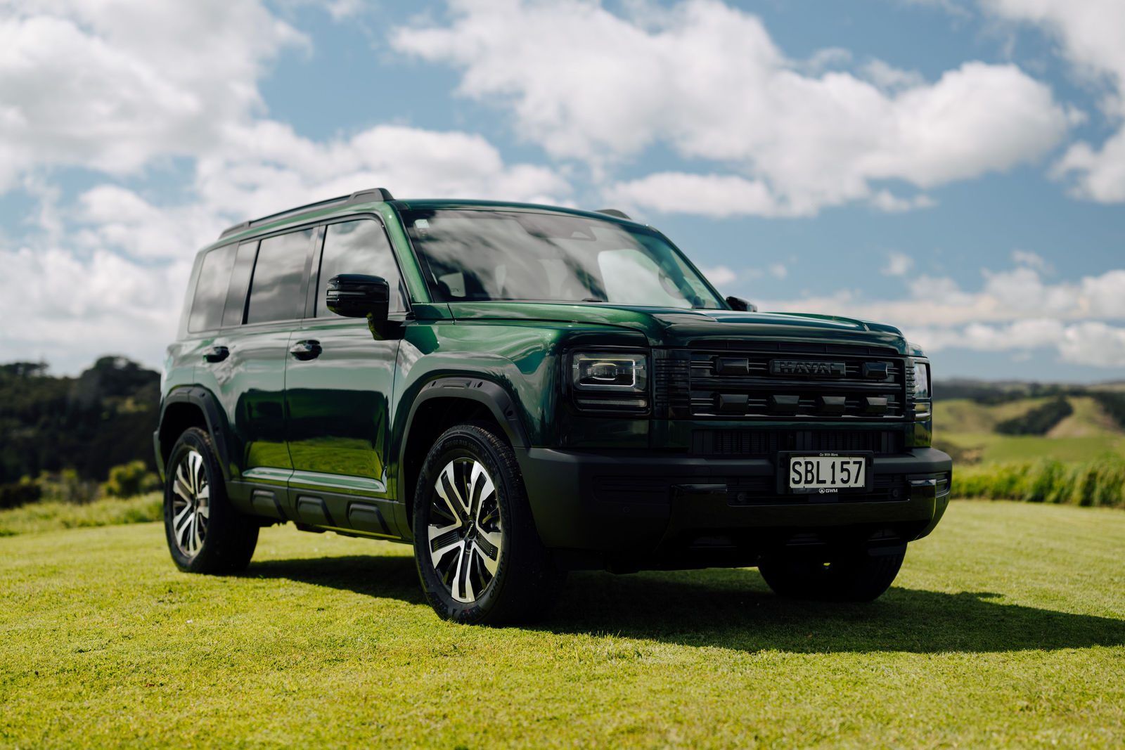 Green Haval H7 front three-quarter view in a paddock