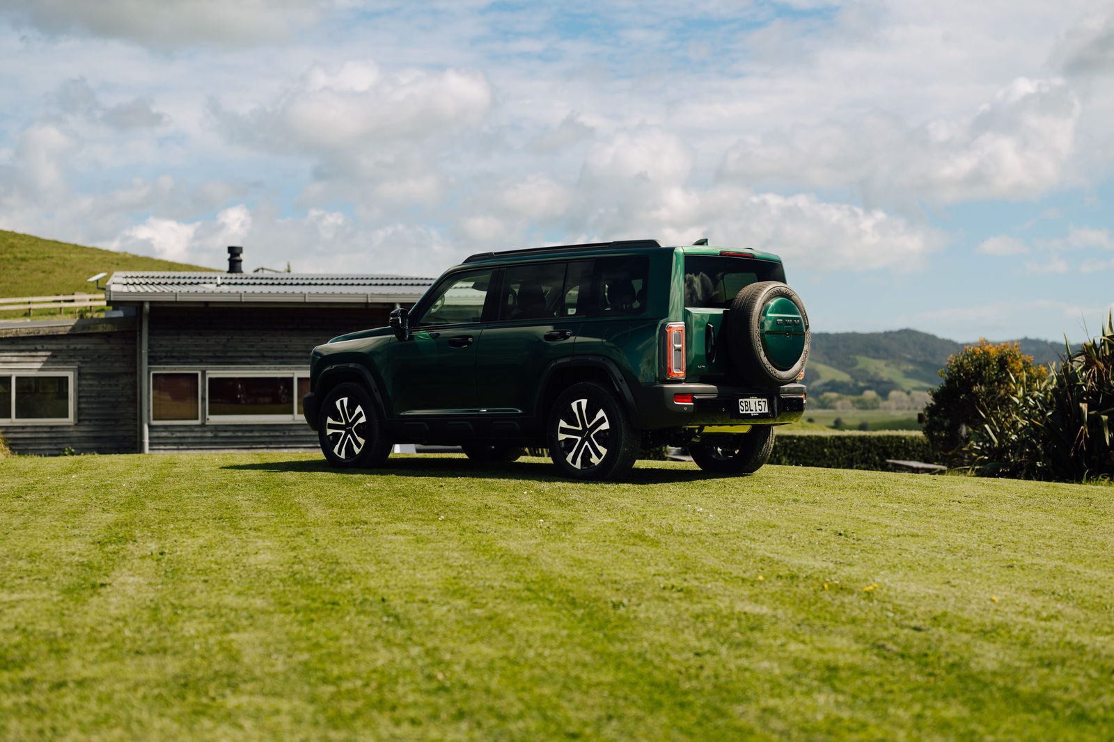 Green Haval H7 parked by a farmhouse