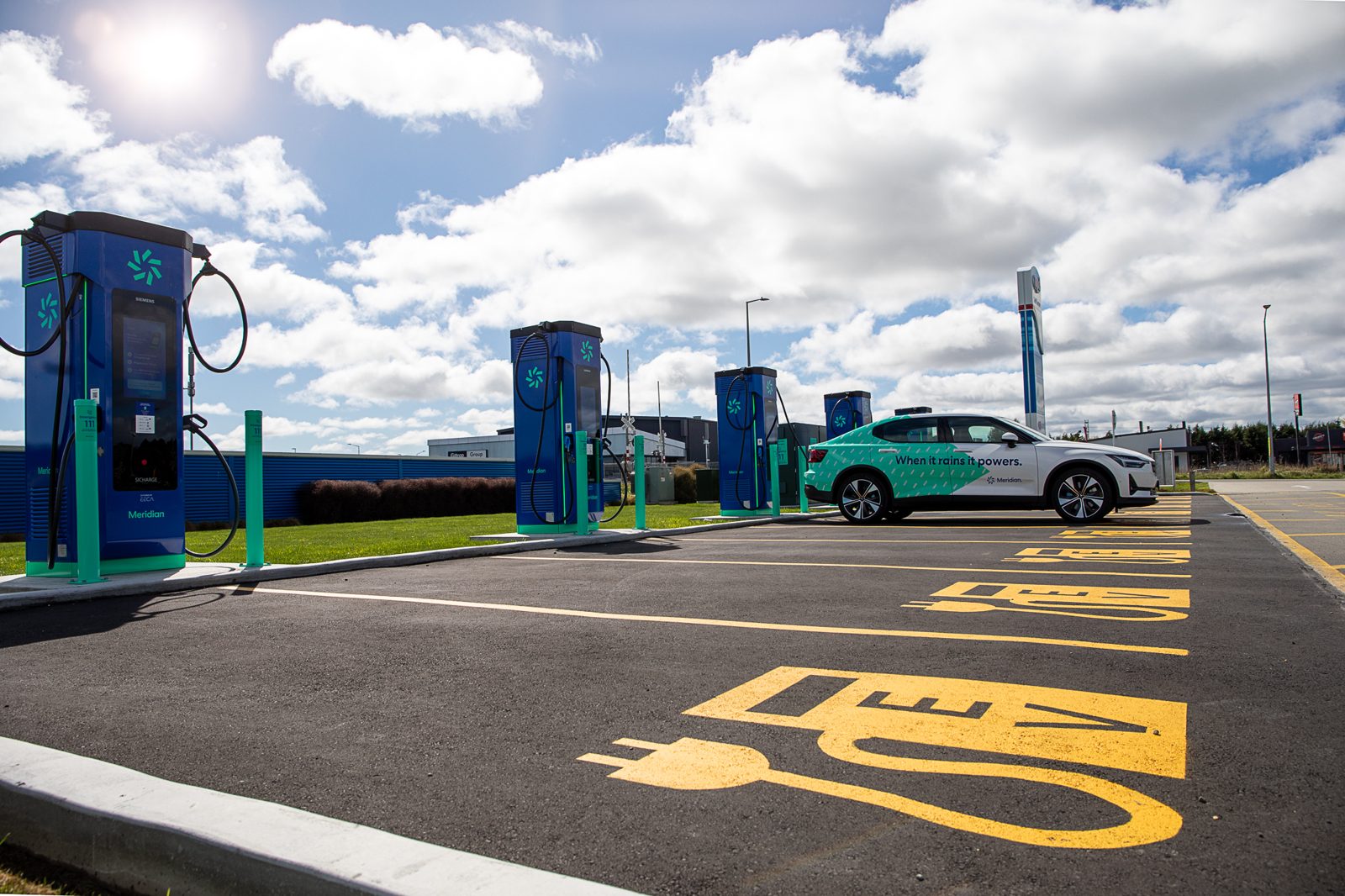 Meridian-branded Polestar 2 beside a row of Meridian rapid EV chargers