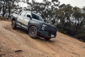 Camouflaged Nissan Navara Pro PHEV prototype climbing a dirt track