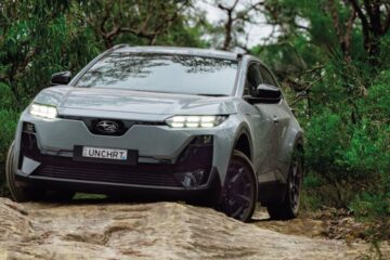 Grey Subaru Uncharted electric SUV climbing a rocky track through bush