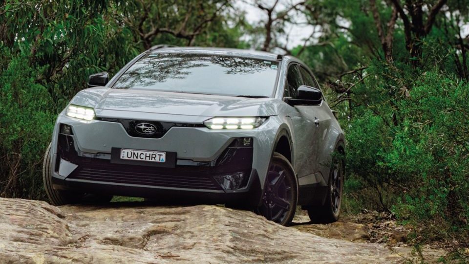 Grey Subaru Uncharted electric SUV climbing a rocky track through bush