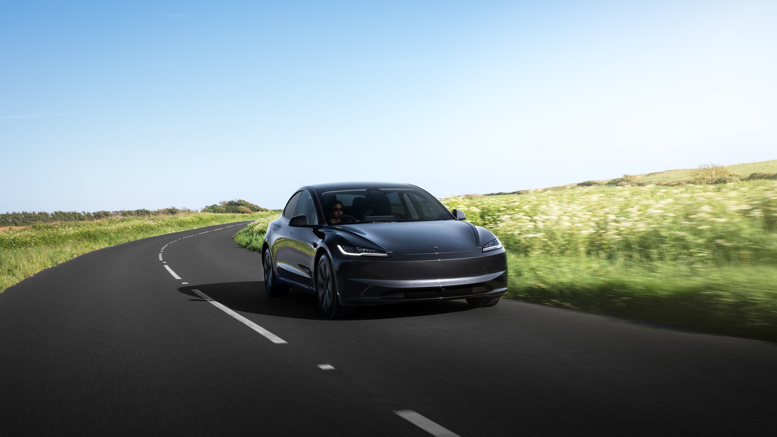 Grey Tesla Model 3 on a rural road
