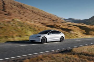 Tesla Model 3 driving through dry hills
