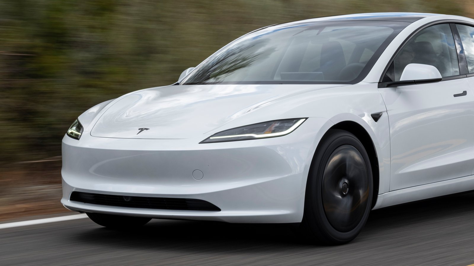 White Tesla Model 3 driving on a country road