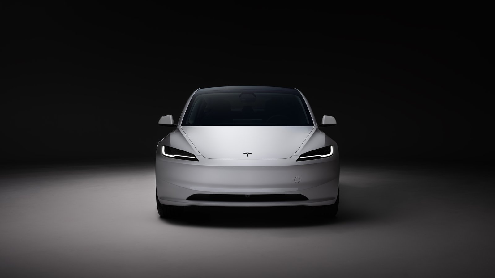 Front view of a white Tesla Model 3 in a studio
