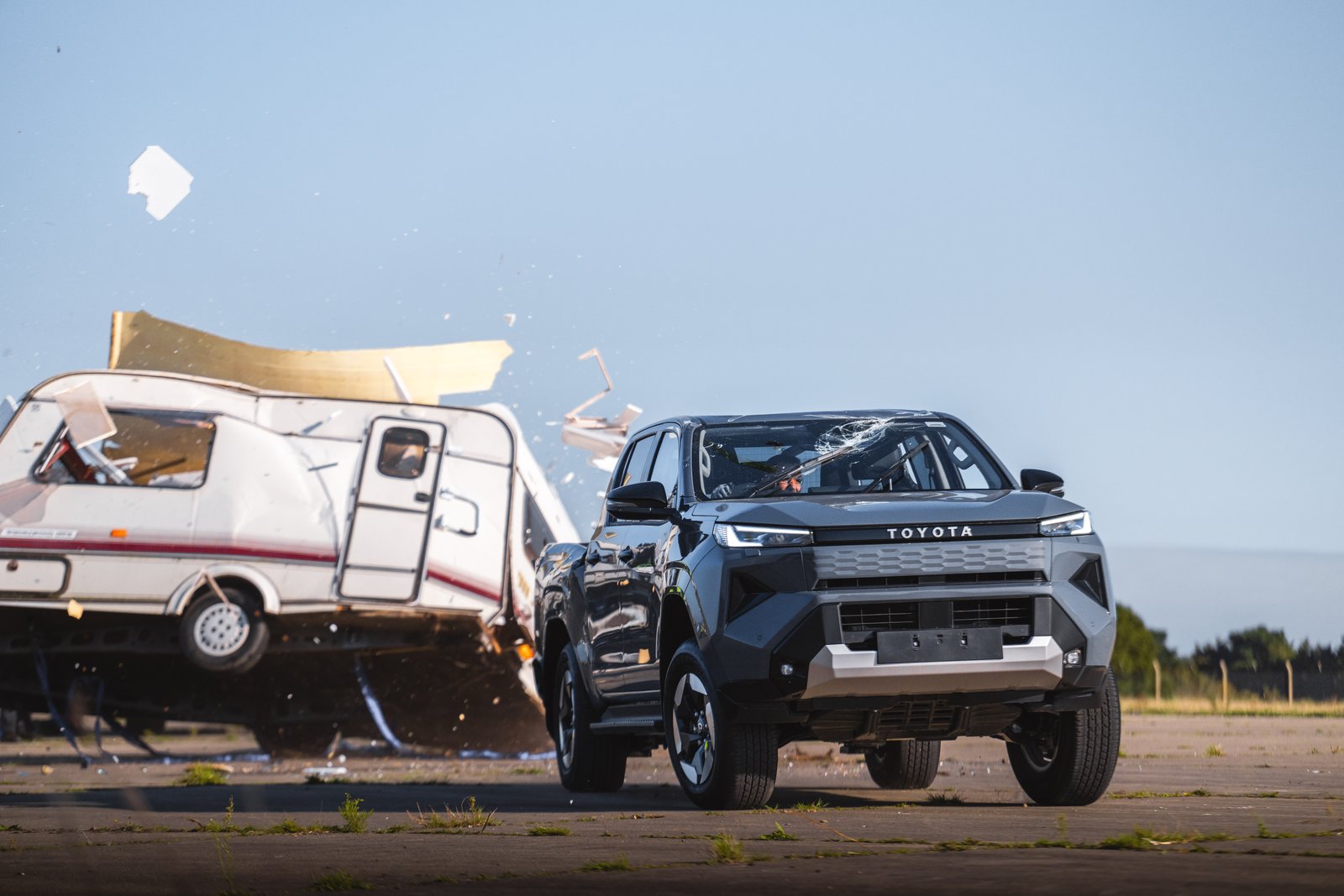Toyota Hilux BEV driving away from the wrecked caravan