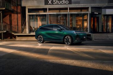 Green XPeng G9L parked outside a building