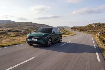 Green updated Zeekr 7X driving on a coastal mountain road